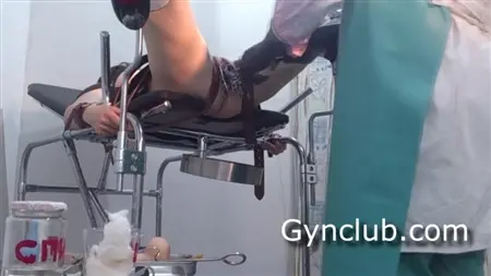 Un patient lié dans un gynécologue gémit lorsqu'un médecin se doigte la chatte